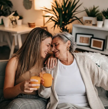 Two woman smiling and drinking juice