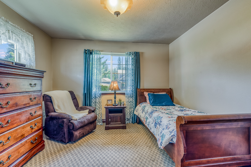 bedroom with dresser and recliner chair